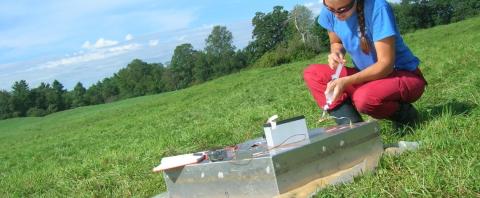 Ecosystems researcher performing a test outdoors in the grass