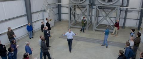 View of people touring a space containing industrial fans