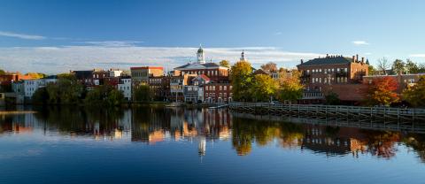 A river view of Exeter, NH. The water is reflecting the shoreline and sky.