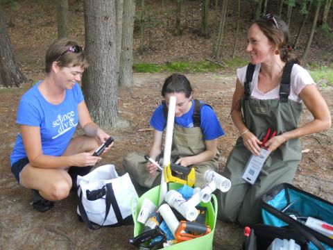 Newport, NH Middle School teacher Jessica Warkentien (left) with Caroline Watson and Sandy Amborn (right) prep the LoVoTECS aquatic sensor for installation. (Ecosystems and Society Project)