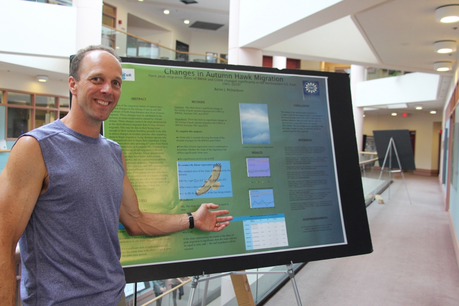 man presenting research poster